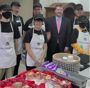  Dr. Houlihan poses with students at the Coffee Nut.